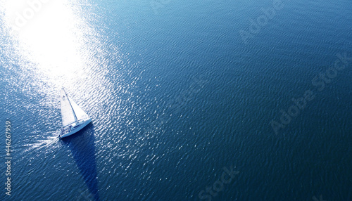 Photography Aerial view of a white yacht with a sail. Ship in the blue sea