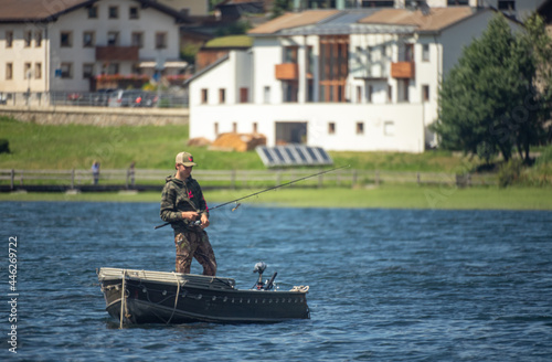 fisherman on boat in a lakeMan fishing from the boat on the pond


