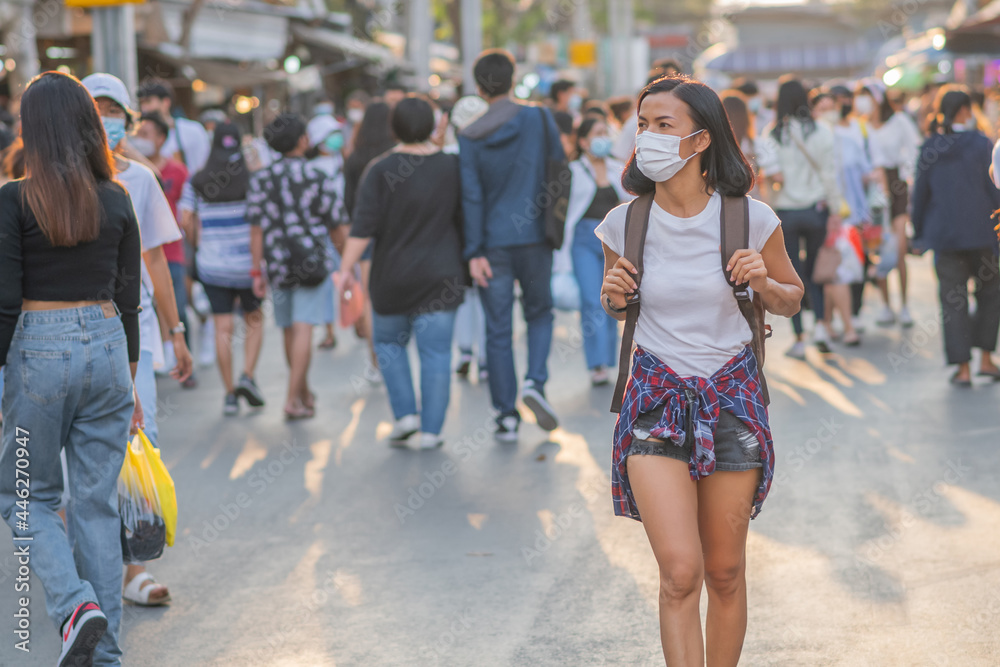 Tourists girls wearing face masks ar street. Happy travel of woman in sunny city centre. Women travel during coronavirus quarantine. Summer vacation. Chatuchak Weekend Market in Bangkok, Thailand