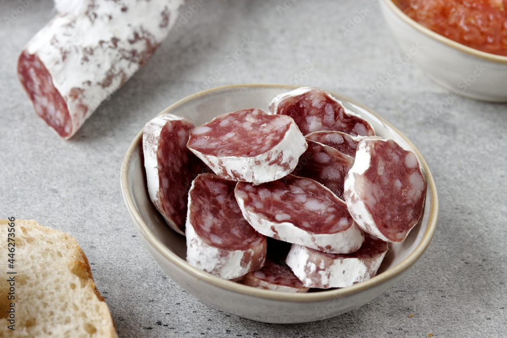 Sliced fuet typical Catalan sausage. Thin dried sausage. Sliced fuet typical Catalan sausage. Thin dried sausage.