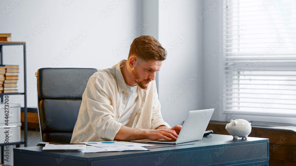 Concentrated businessman signs contract online and raises hands Concentrated businessman signs contract online and raises hands