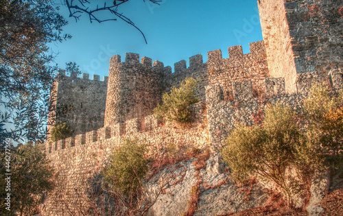 Walls of the medieval castle in Montemor-o-Velho, enlightened by yellow-light-sunset photo