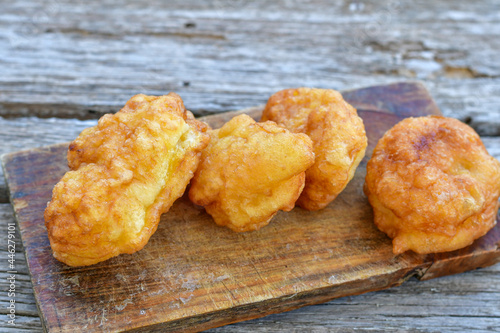 Traditional Bulgarian home made deep fried  patties  covered with sugar  оn rustic backgroud.Mekitsa or Mekica,  on wooden  rustic  background. Made of kneaded dough that is deep fried  photo