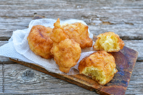 Traditional Bulgarian home made deep fried  patties  covered with sugar  оn rustic backgroud.Mekitsa or Mekica,  on wooden  rustic  background. Made of kneaded dough that is deep fried  photo