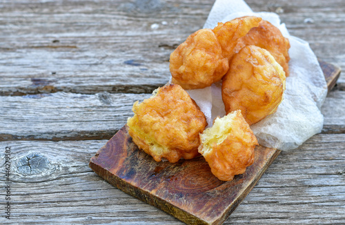 Traditional Bulgarian home made deep fried  patties  covered with sugar  оn rustic backgroud.Mekitsa or Mekica,  on wooden  rustic  background. Made of kneaded dough that is deep fried  photo