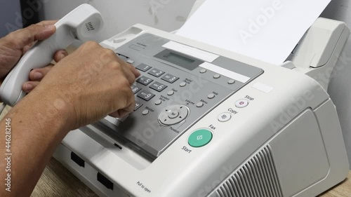 hand man is using a fax machine in the office, equipment for data transmission. photo