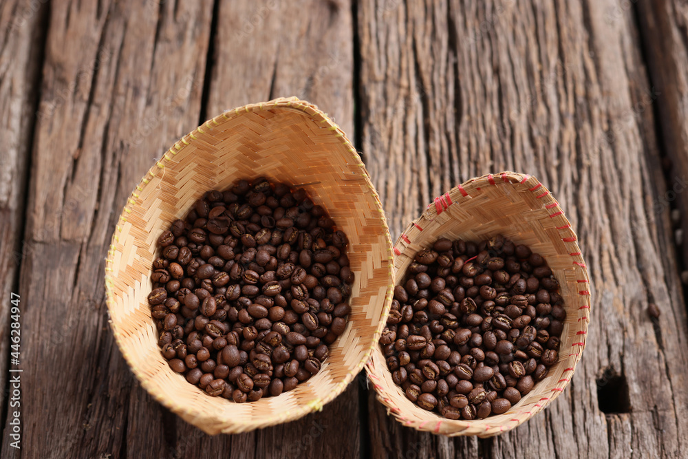 hand hold Coffee Beans Peaberry small size picking . a cup and log wooden background. Selective focus on foreground with copy space. hand hold Coffee Beans Peaberry small size picking . a cup and log wooden background. Selective focus on foreground with copy space.