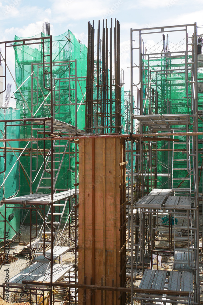 PENANG, MALAYSIA -JUNE 3, 2021: Column timber formwork and reinforcement bar at the construction site. Installed by construction workers. The formwork supported by the temporary wood support.