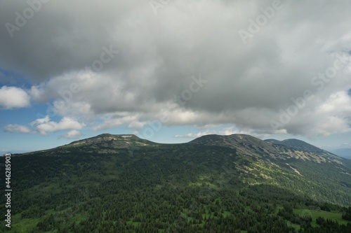 AERIAL: an epic panorama of mountains with thunderclouds. shot of adventure hiking in mountains alone outdoor active lifestyle travel vacations. Conceptual scene