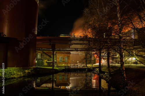 Factory at night with creek
