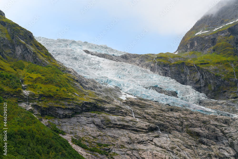 Detail shot of Boyabreen Glacier flowing down the rocky mountain. Norwegian landscape on a day of summer. Detail shot of Boyabreen Glacier flowing down the rocky mountain. Norwegian landscape on a day of summer.