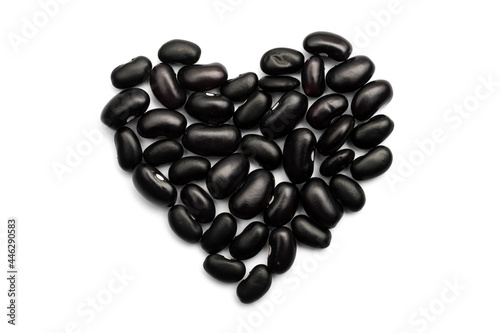 Heart shape made with black caribbean beans isolated on white background