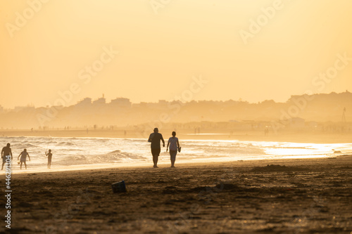 Obraz w ramie sunset on the beach of huelva with silhouettes of people