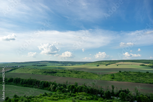 Summer landscape and white clouds over green fields