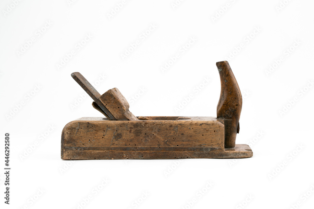 Horizontal low angle studio shot of small vintage wood planer isolated on white background. Old carpenter tool with wood worm holes in it. Carpentry concept. - obrazy, fototapety, plakaty 