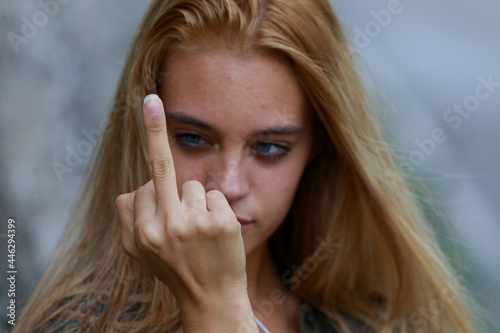 Rude vindictive young woman giving the middle finger photo