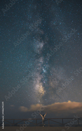 Siluetas hacia campo de estrellas en el cielo y la vía láctea. Castillo y personas.