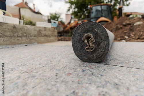 Worker prepares geotextile for the roof, covers it with synthetic PVC membrane photo