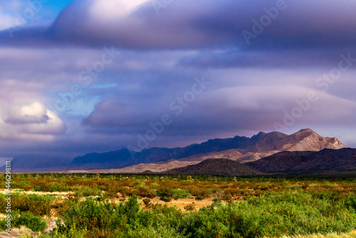 dramatic sunrise with storm clouds over mountains and plains