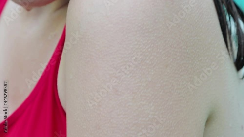 Close-up of a female hand covered with goose bumps. A wet woman in a red bathing suit is shivering from the cold. photo