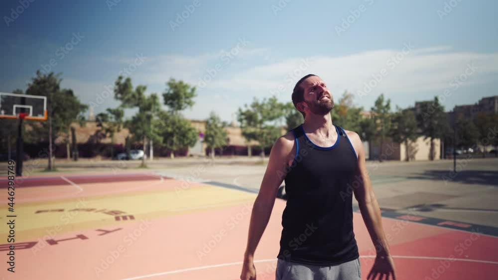 tired basketball player on the basketball field throws the ball into