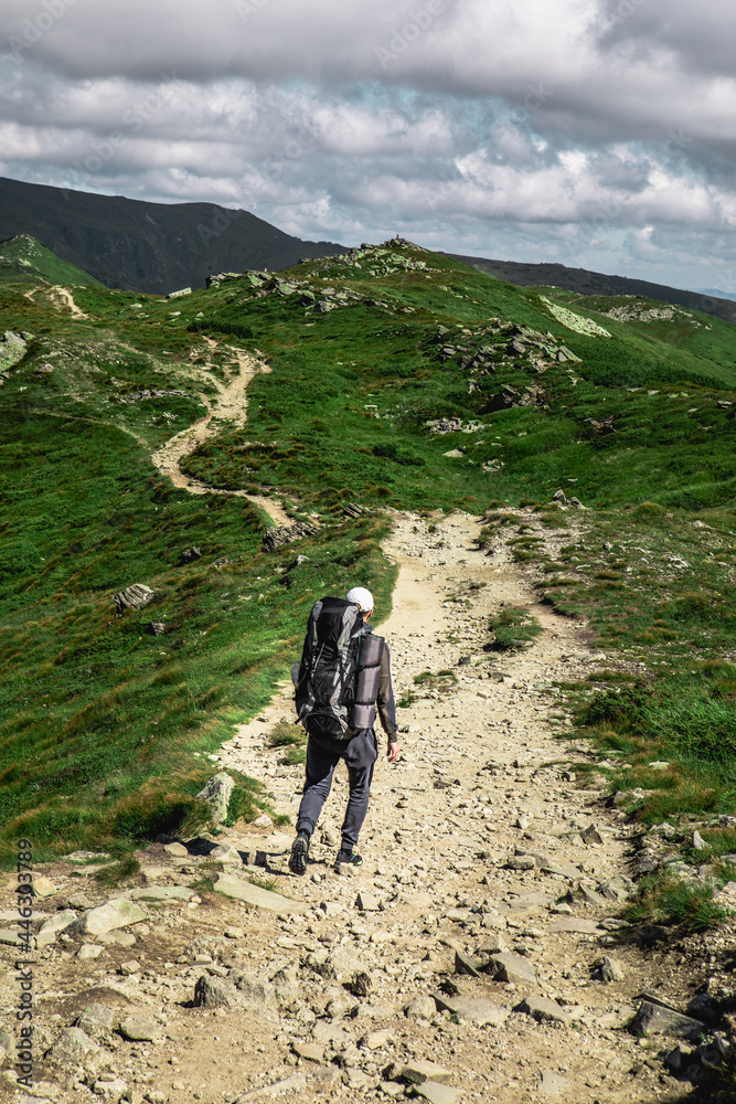 Fototapeta premium young hiker man in mountains. summer trekking path