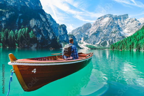 man in big wooden boat at mountain lake
