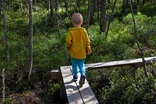 Umea, Norrland Sweden - June 7, 2021: little guy walks on wooden walkway outdoors