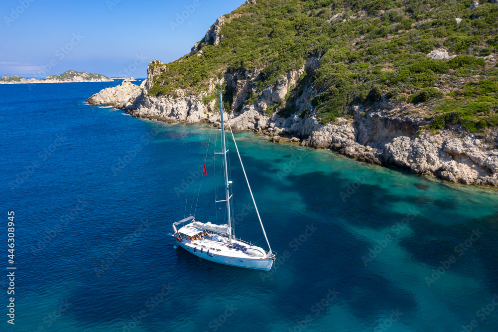 yacht in azure transparent sea. Aerial view of sailboat