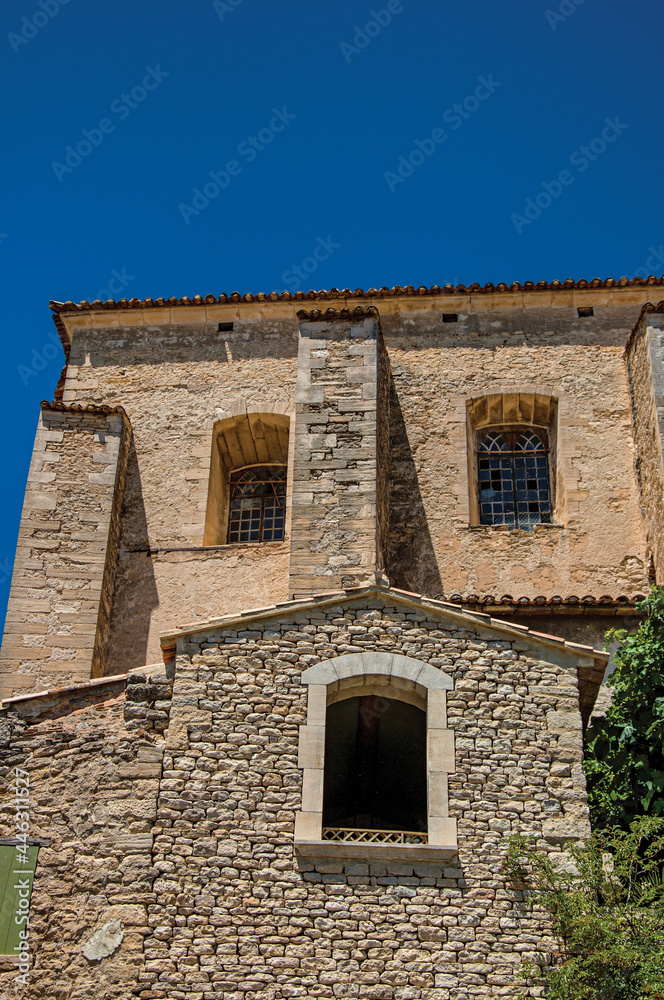 Facade of stone house looking like a face, in an alley of the historical city center of Gordes. Provence region, southeastern France.