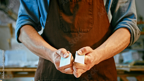 Young man in apron holding a piece of stone close-up