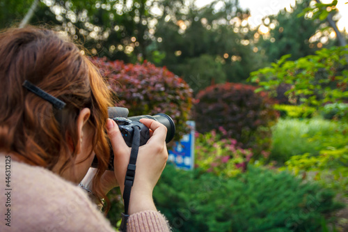 Young girl shooting outdoors using DSLR