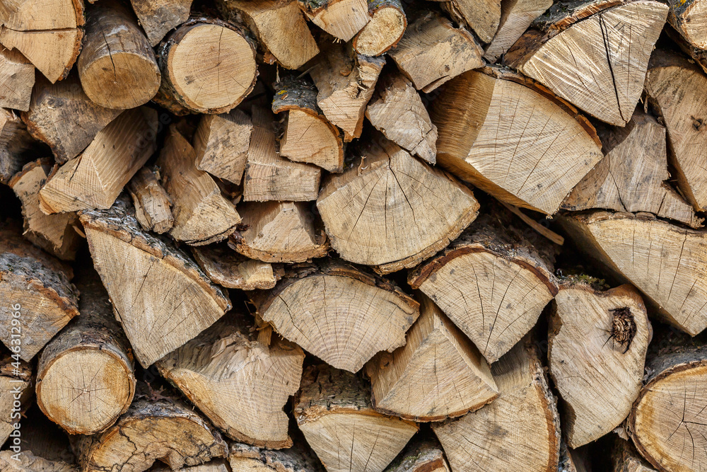 Background of hewed smooth wooden logs. Cut wood texture. Pile of chopped fire wood prepared for winter Background of hewed smooth wooden logs. Cut wood texture. Pile of chopped fire wood prepared for winter