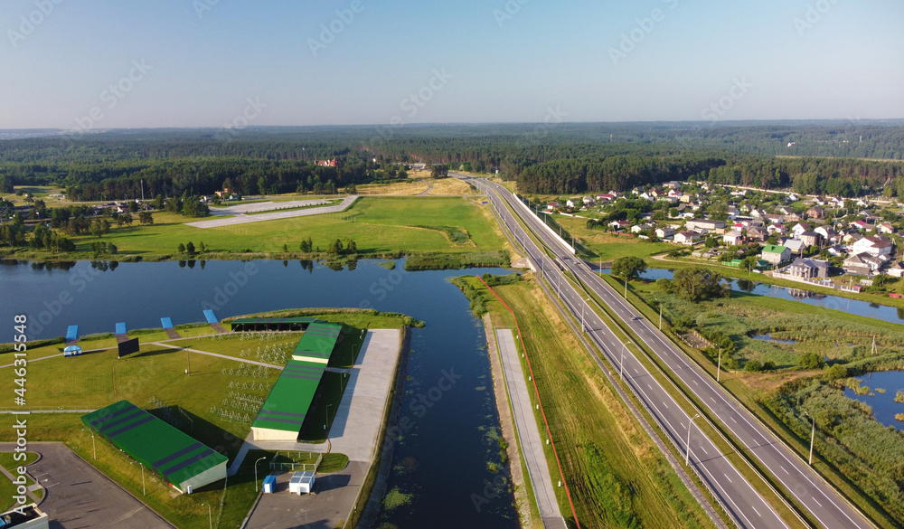 Aerial view of highway road and green meadows and fields