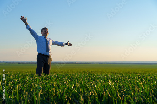 businessman poses in a green field, freelance and business concept, green grass and blue sky as background