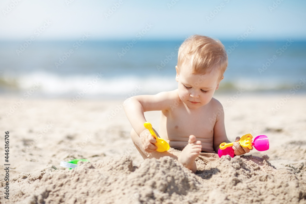 Happy toddler playing on the beach on a sunny day Happy toddler playing on the beach on a sunny day