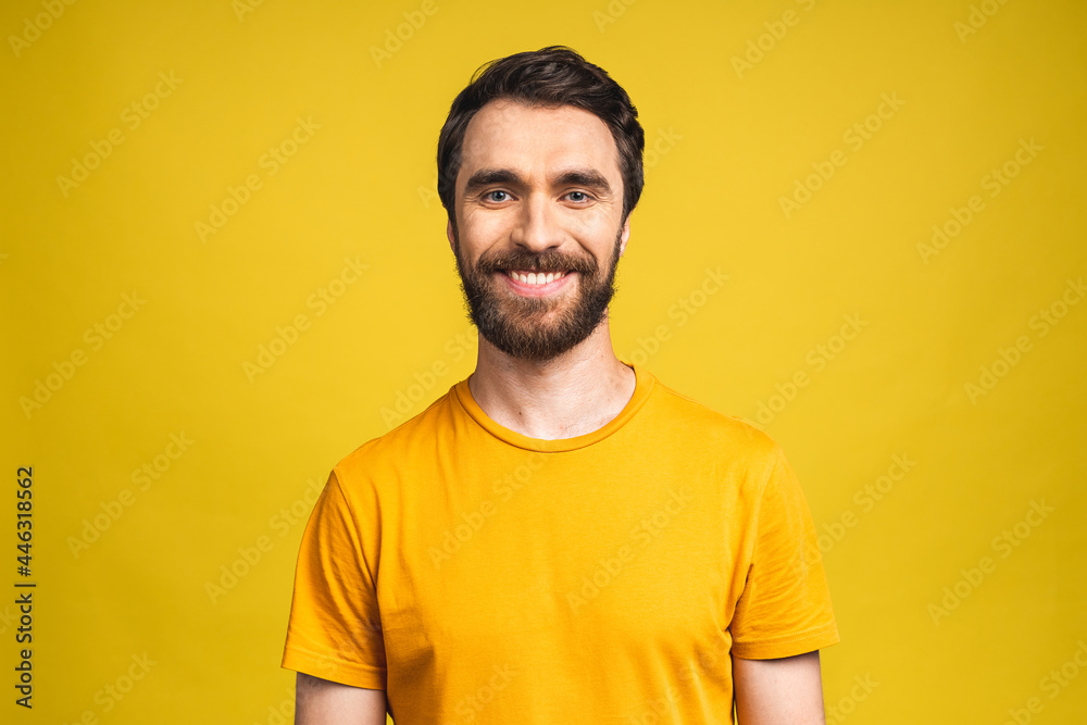 Happy young man. Portrait of handsome young bearded man in casual smiling while isolated over yellow background. Happy young man. Portrait of handsome young bearded man in casual smiling while isolated over yellow background.
