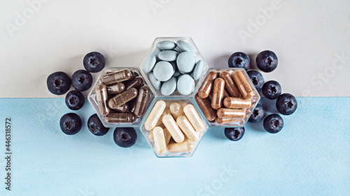 Various capsules with dietary supplements or vitamines and fresh strawberry