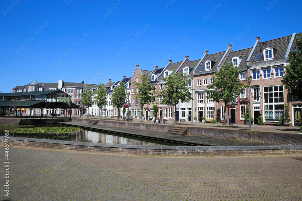 Helmond, Netherlands - July 10. 2021: View over water canal on traditional old dutch houses in summer with blue sky