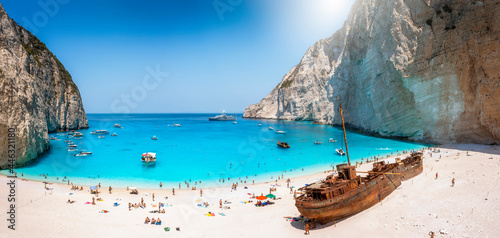 Panoramic view of the famous Navagio shipwreck beach on Zakynthos island, Greece, with people enjoying the light blue colored sea photo