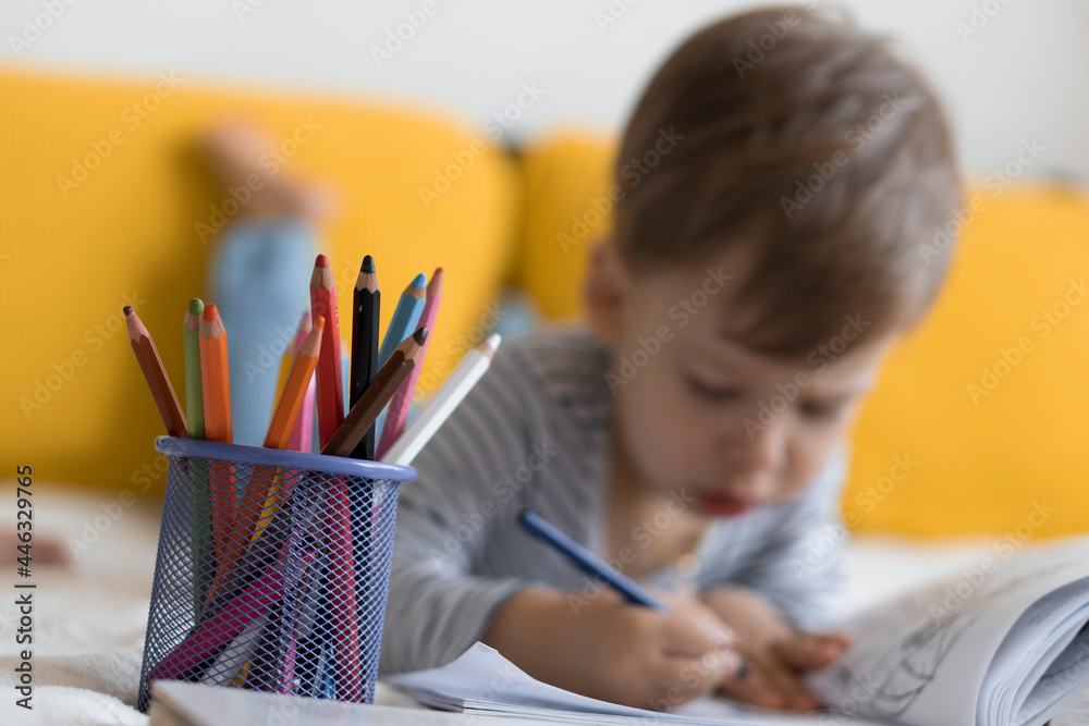 smart smiling preshool toddler children boy and girl draw with pencils lying on their stomach at yellow bed. little cute reader have fun, happy kid on quarantine at home. Friendship, family, education smart smiling preshool toddler children boy and girl draw with pencils lying on their stomach at yellow bed. little cute reader have fun, happy kid on quarantine at home. Friendship, family, education