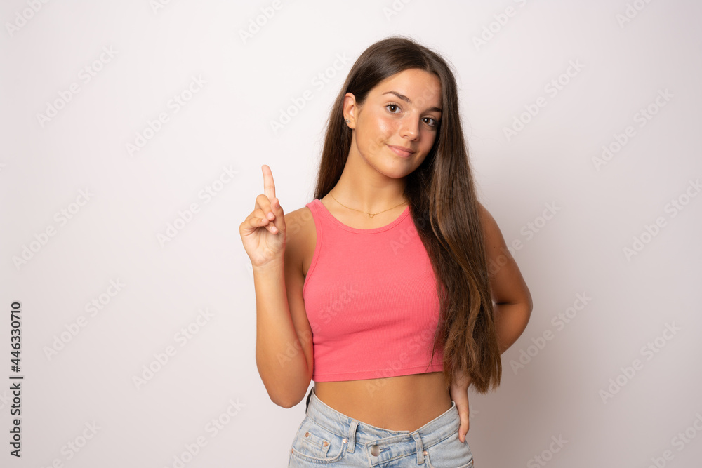 Young girl in summer clothes pointing finger up isolated over white background. Young girl in summer clothes pointing finger up isolated over white background.