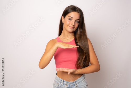 Young caucasian woman posing isolated holding something with both hands  product presentation.