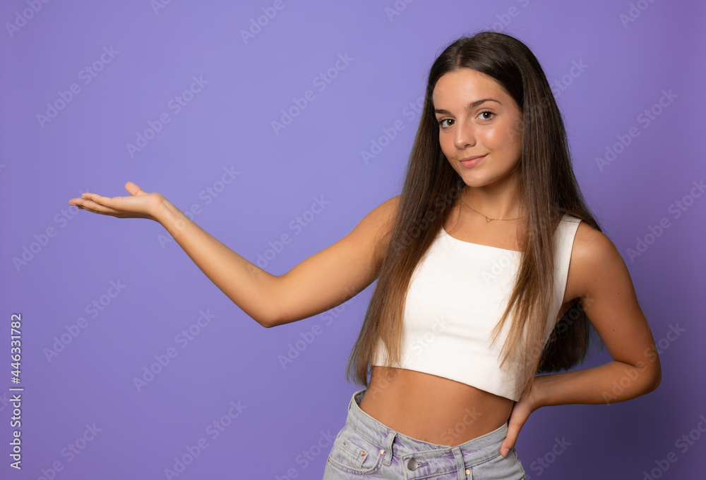 Portrait of a cheerful girl holding copy space on the palm isolated on a purple background Portrait of a cheerful girl holding copy space on the palm isolated on a purple background