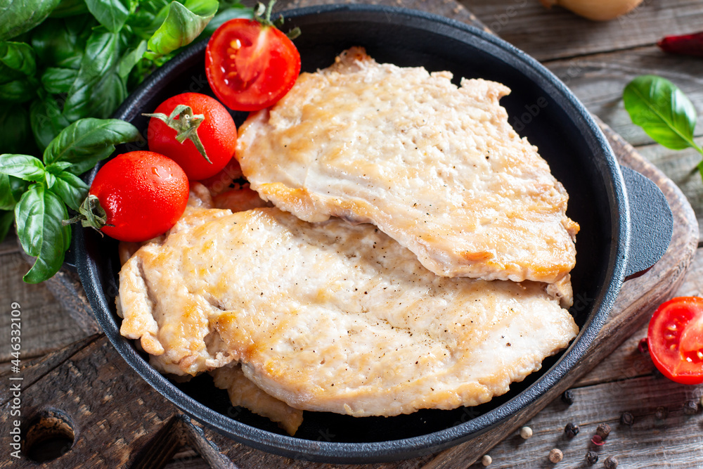 Fried chicken chop. Home fried chicken chop with tomatoes on a wooden table. Rustic style.