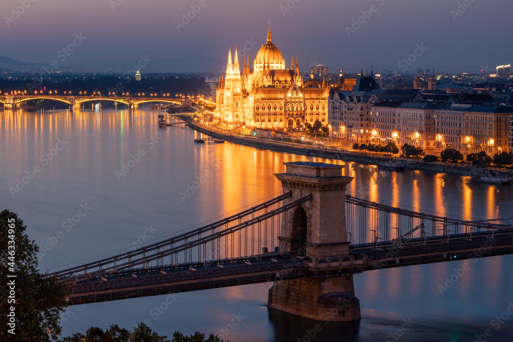 View of the Hungarian Parliament building and chain bridge in Budapest, in the evening