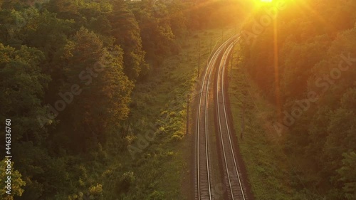Railway track in a coniferous forest at dawn. View from the drone.