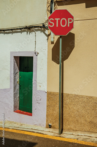 STOP road sign in front colorful house with wooden door on sunny day in Campo Maior. A little town with Moorish and medieval influences in Portugal. photo