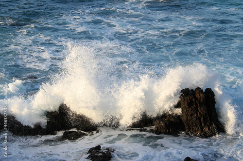 sea landscape, blue sea waves crashing against the rocks, big splash in the ocean, white sea foam, sun