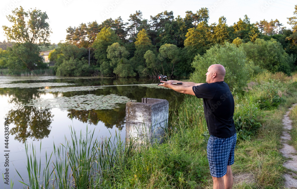 A man throws a fishing rod and catches fish in a pond. A man throws a fishing rod and catches fish in a pond.